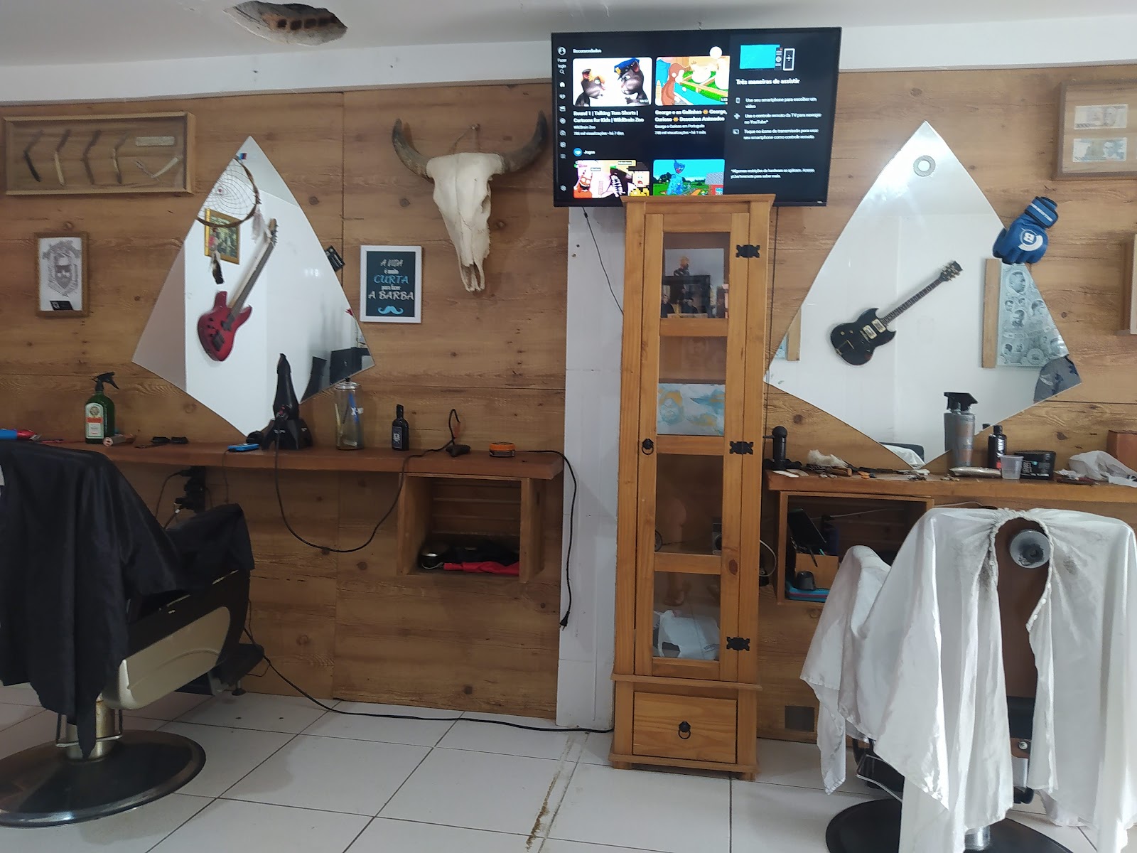 Bancada e espelhos da Barbearia Lucão, com detalhes de decoração na parede